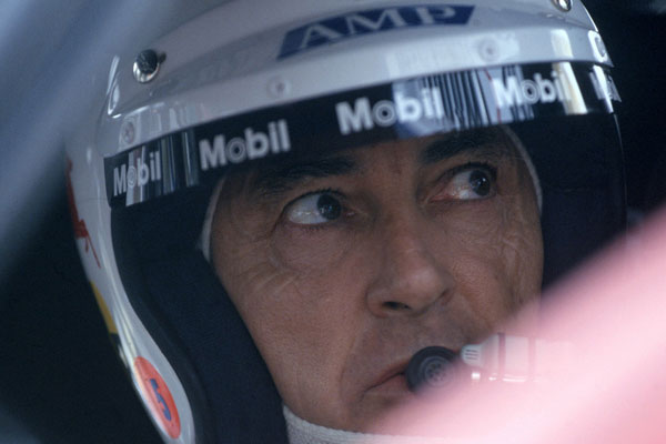 Peter Brock mówi do mikrofonu i nosi zestaw słuchawkowy