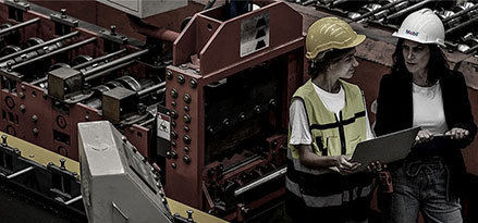 Pracownik Mobil i klient patrzący na iPada w zakładzie produkcyjnym