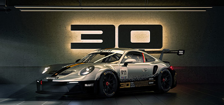 Porsche 911 GT3 Cup z napisem z okazji 30. urodzin w tle
