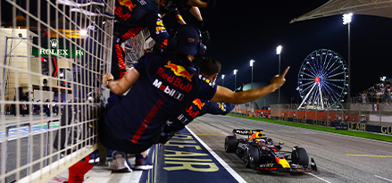 Zespół Red Bull świętujący wygraną, podczas gdy pojazd przekracza linię mety 