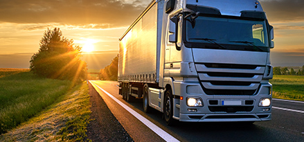 Lorry drives away from sunset