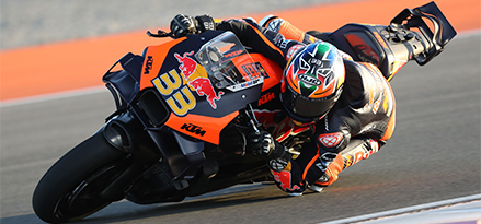 Motocyklista na motorze Red Bull pokonuje zakręt z dużą prędkością