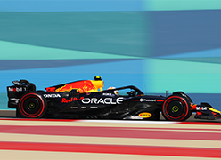 a Red Bull racing F1 car driving along a track with a green background