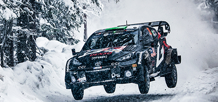 Samochód rajdowy Toyoty przelatuje przez śnieg