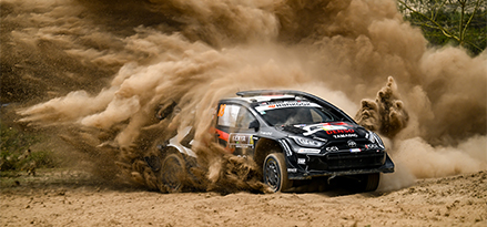 Wyścigowa Toyota wchodzi w zakręt, wzbijając tuman pyłu