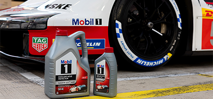 Trzech członków zespołu Porsche siedzi na swoim samochodzie wyścigowym